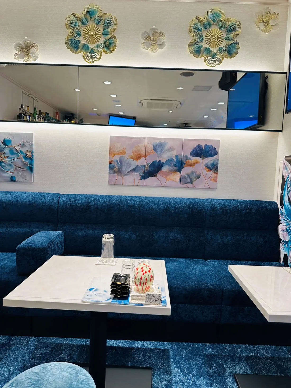 花のオブジェとアートが彩る新店舗のソファ席